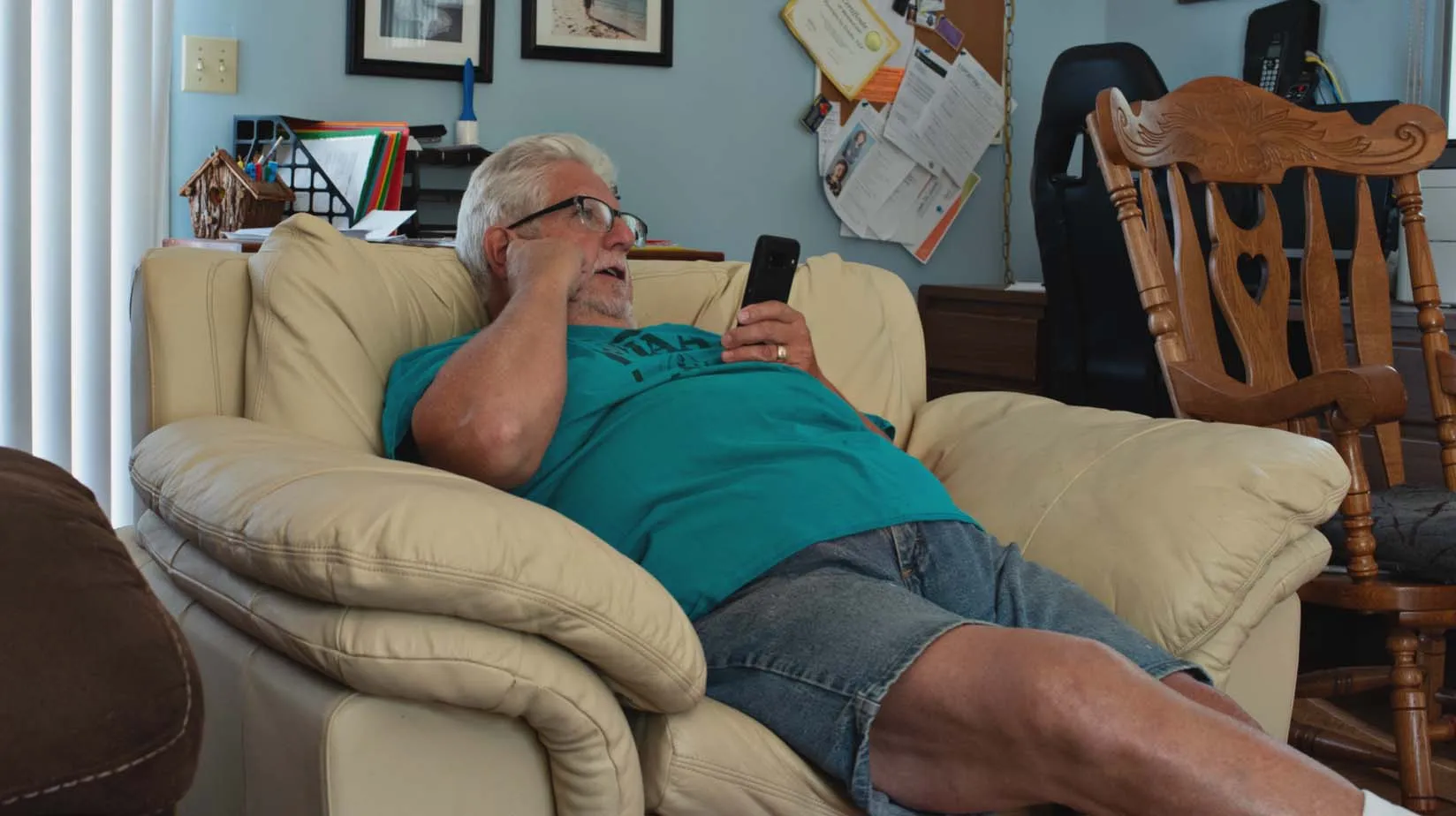 Man lying on couch while on the phone