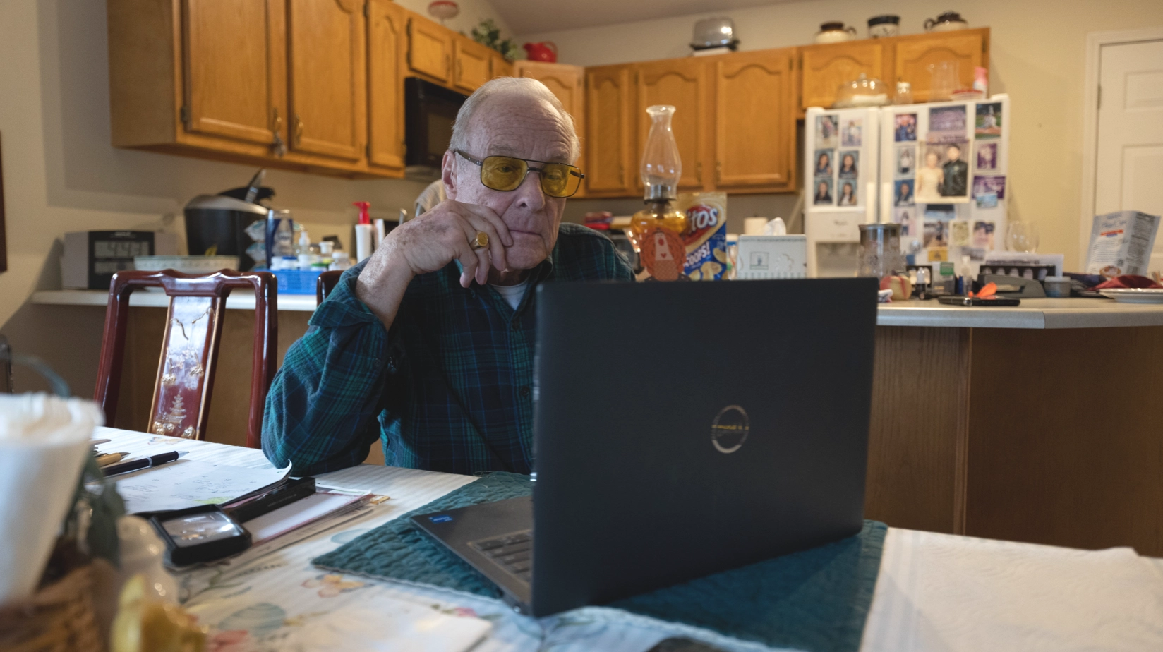 Old man using laptop on dining table